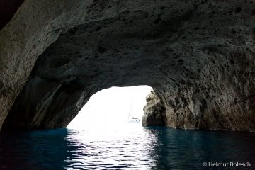 Höhle Sykia mit Segelboot, Insel Milos, Griechenland – Foto © Helmut Bolesch